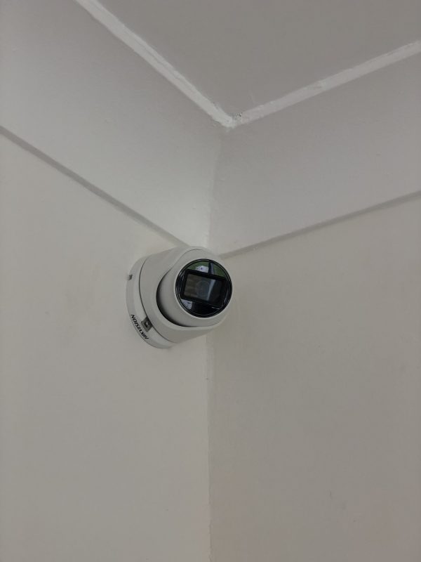 A camera mounted on the wall of a room.